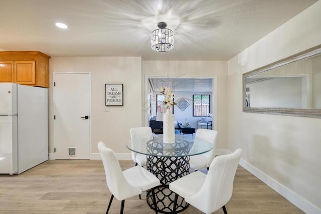 dining space with a chandelier and light wood-type flooring