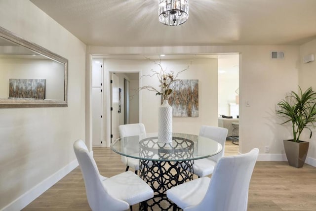 dining area featuring hardwood / wood-style flooring and a chandelier