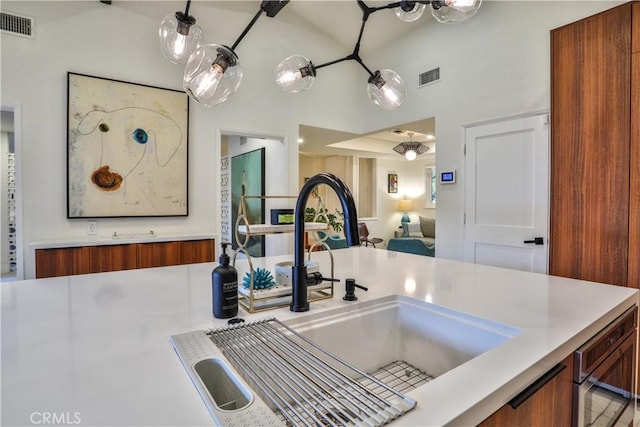 kitchen featuring sink, wall oven, and vaulted ceiling