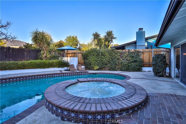 view of pool with a patio area and an in ground hot tub