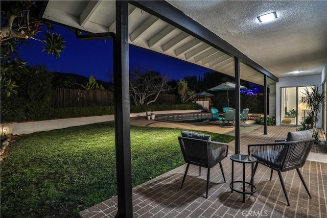 patio at twilight with a lawn and a swimming pool