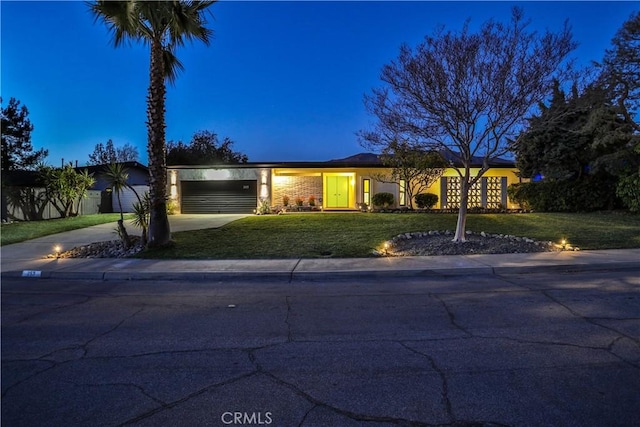 ranch-style house featuring a front yard and a garage