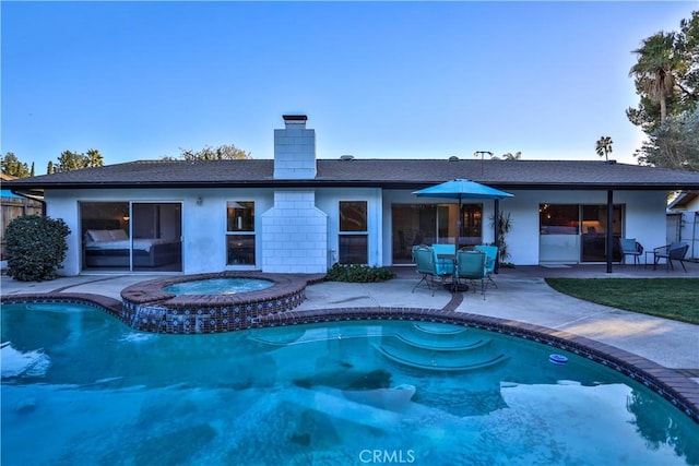 view of pool featuring a patio and an in ground hot tub