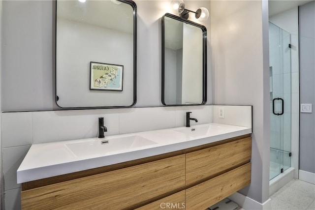 bathroom featuring a shower with shower door, vanity, and decorative backsplash