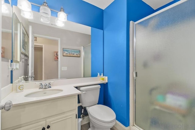 bathroom with toilet, a shower with shower door, and vanity