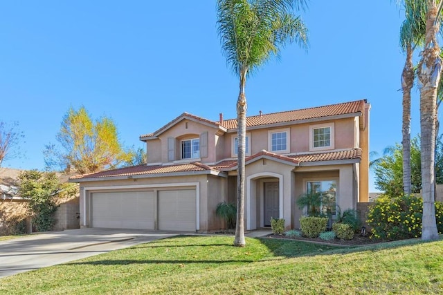 mediterranean / spanish house with a front yard and a garage