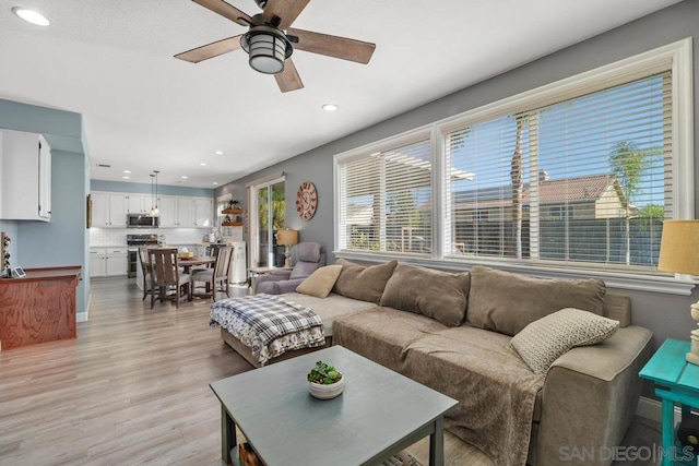 living room with ceiling fan and light wood-type flooring