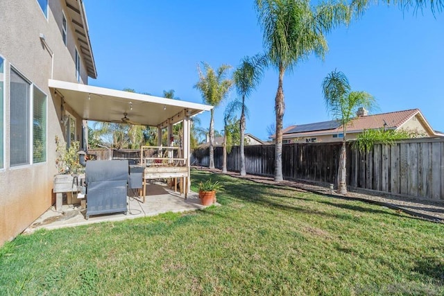 view of yard with ceiling fan and a patio