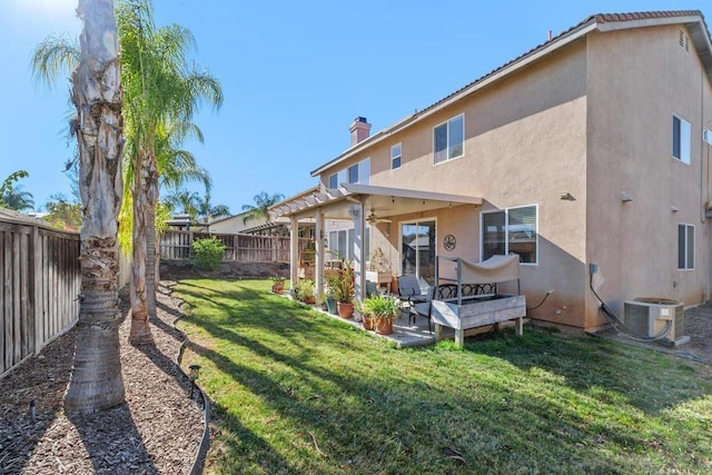 rear view of property featuring a patio, a lawn, and central AC