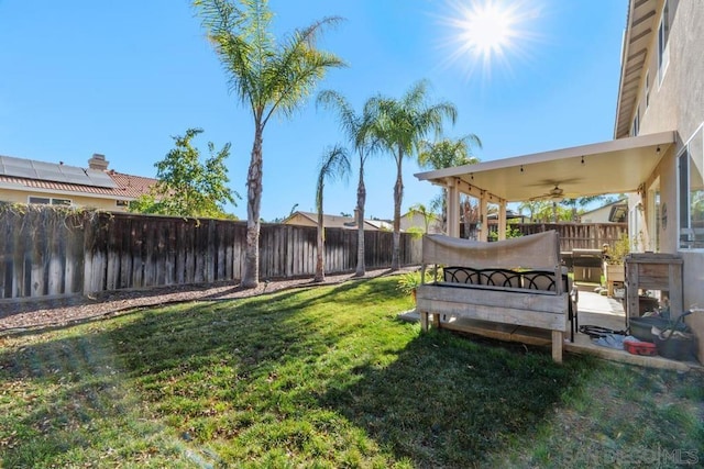 view of yard with ceiling fan and a patio