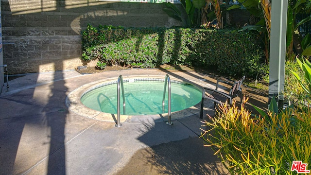 view of swimming pool featuring an in ground hot tub