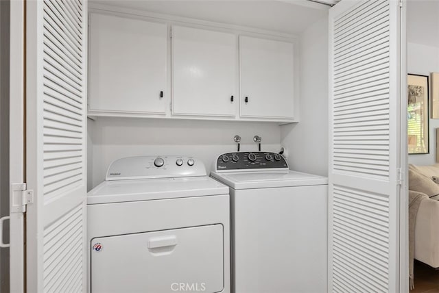 laundry area featuring washer and dryer and cabinets