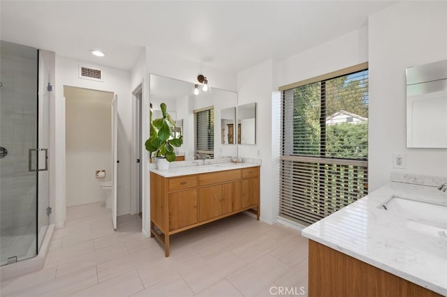 bathroom featuring toilet, vanity, an enclosed shower, and tile patterned floors