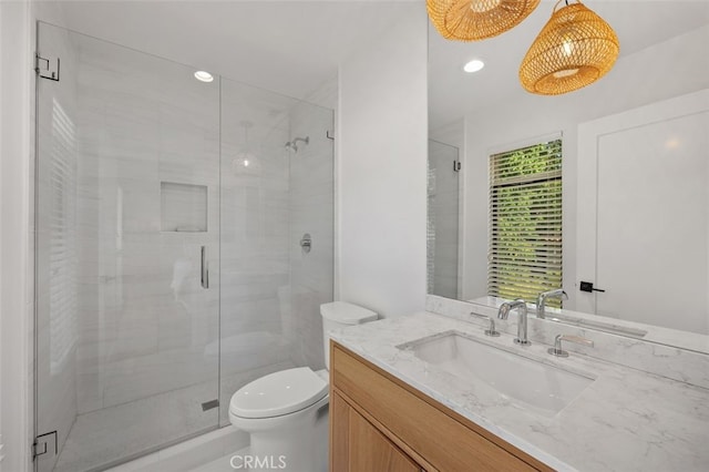 bathroom featuring toilet, vanity, and walk in shower