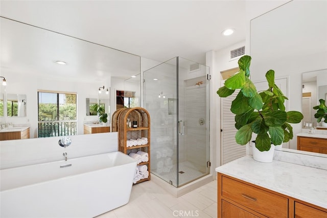 bathroom with tile patterned flooring, vanity, and plus walk in shower