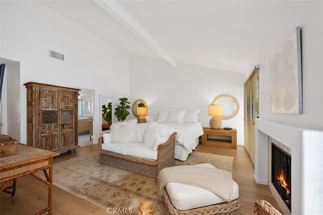 bedroom featuring beam ceiling and light wood-type flooring