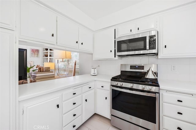 kitchen featuring tasteful backsplash, white cabinets, light tile patterned floors, and stainless steel appliances