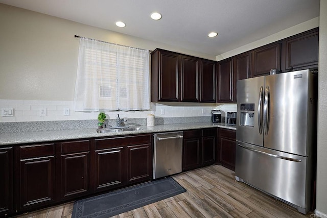 kitchen featuring light hardwood / wood-style floors, sink, dark brown cabinetry, and appliances with stainless steel finishes