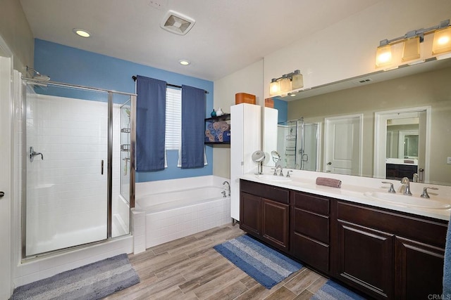 bathroom with vanity and shower with separate bathtub