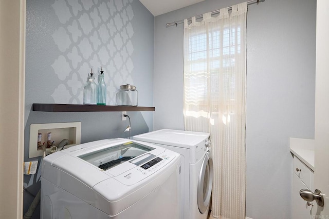 washroom featuring washing machine and clothes dryer and cabinets