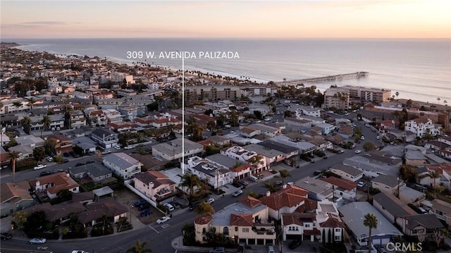 aerial view at dusk featuring a water view