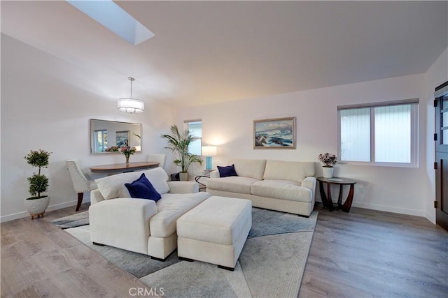 living room with a skylight and light wood-type flooring