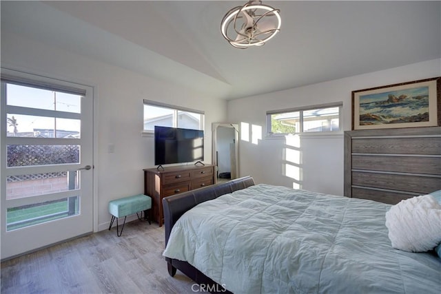 bedroom with lofted ceiling and light hardwood / wood-style floors