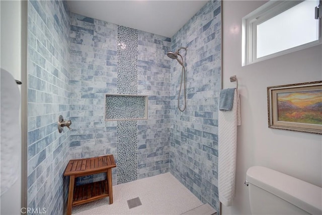 bathroom featuring toilet and tiled shower