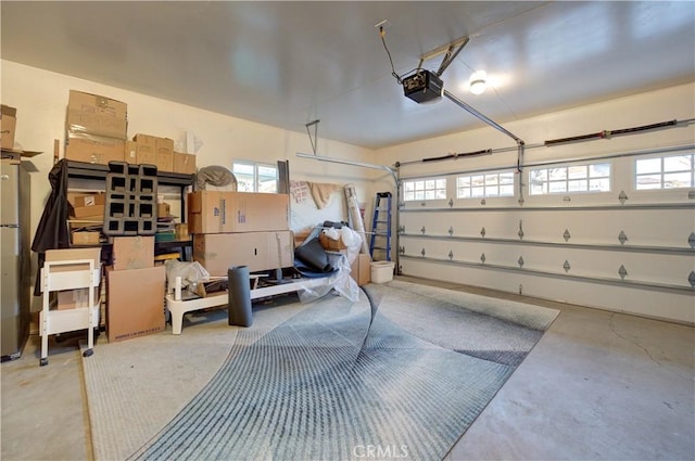 garage with stainless steel refrigerator and a garage door opener