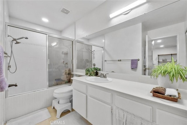 full bathroom featuring enclosed tub / shower combo, vanity, and toilet