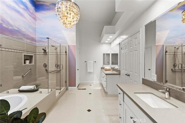 full bath featuring a stall shower, two vanities, and a sink