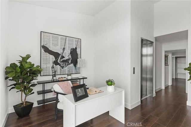 office featuring elevator, baseboards, and dark wood-type flooring