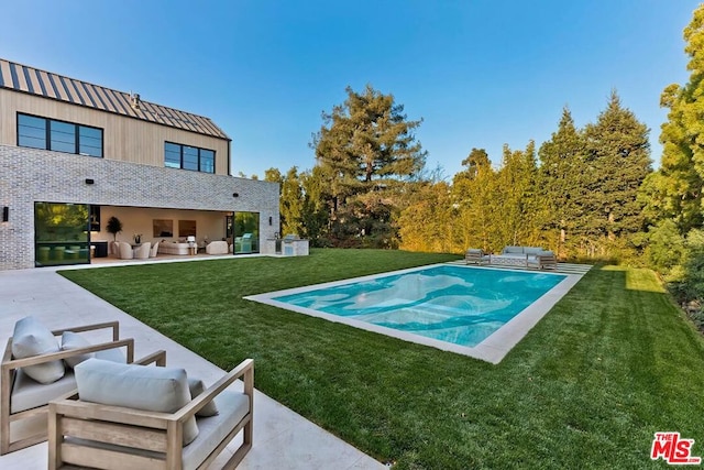 view of swimming pool featuring an outdoor living space, a patio area, and a yard