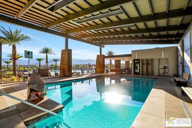 view of swimming pool with a pergola and a mountain view