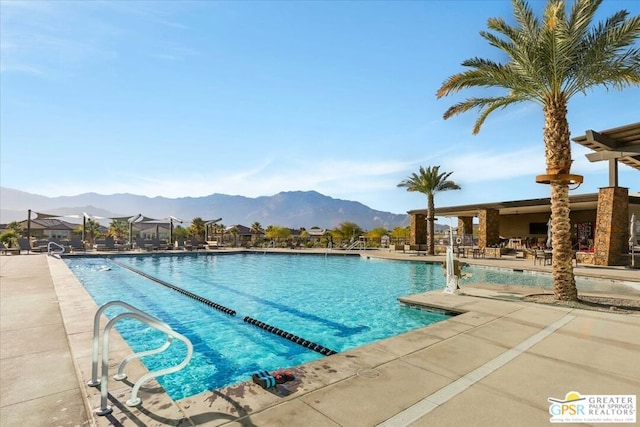 view of pool with a patio area and a mountain view