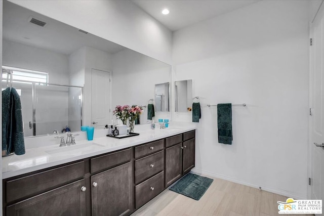 bathroom with walk in shower and vanity