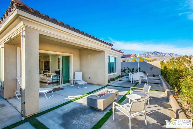 view of patio with a mountain view and a fire pit