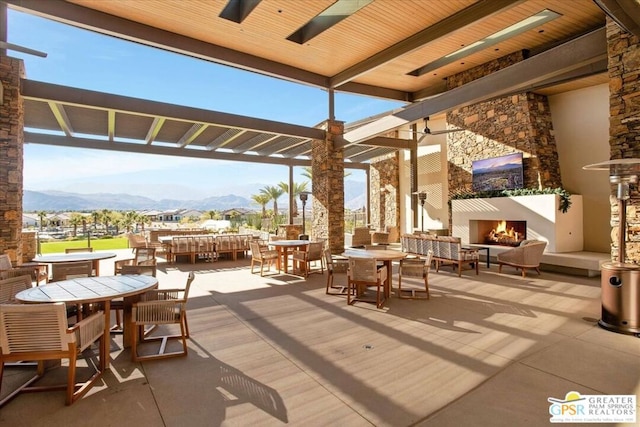 view of patio / terrace with a mountain view and an outdoor living space with a fireplace