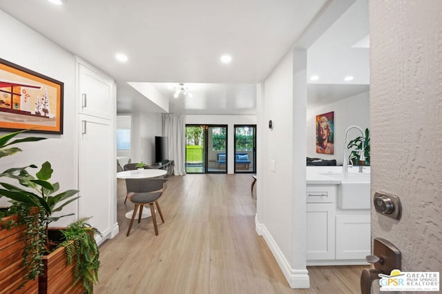 hall featuring light hardwood / wood-style floors and sink