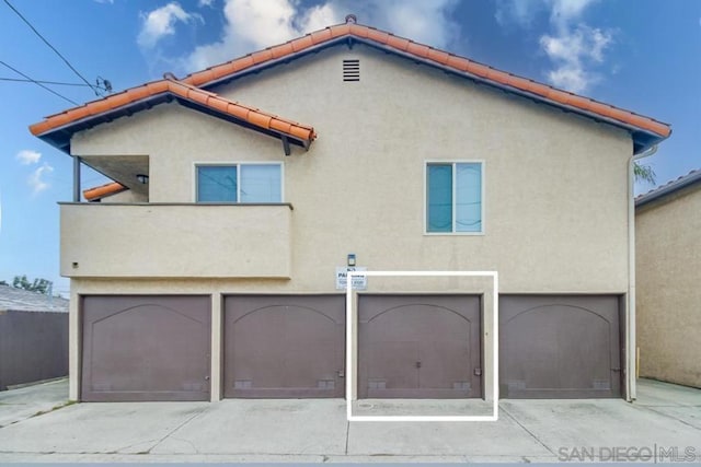 back of house featuring a garage and a balcony