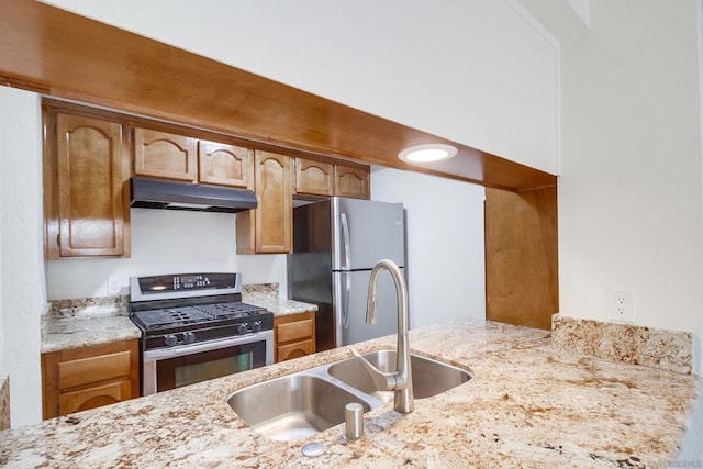 kitchen featuring light stone countertops, stainless steel appliances, and sink