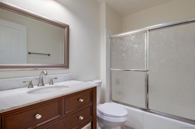 full bathroom featuring toilet, vanity, and shower / bath combination with glass door