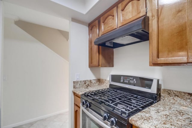 kitchen featuring stainless steel gas stove and light stone counters