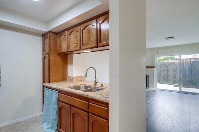 kitchen with light stone counters, sink, and dishwasher