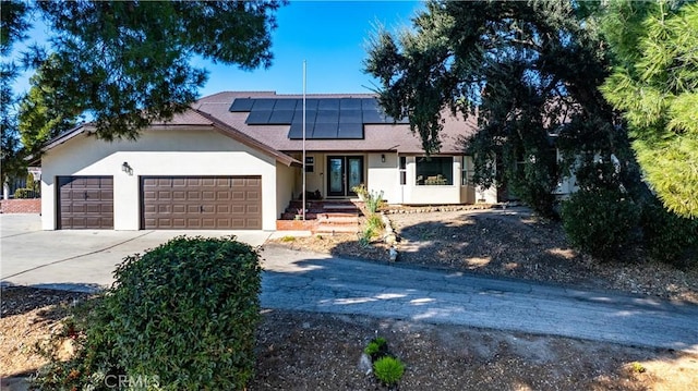 view of front of home with a garage and solar panels