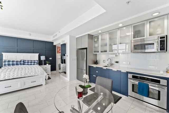 bedroom featuring stainless steel fridge and sink