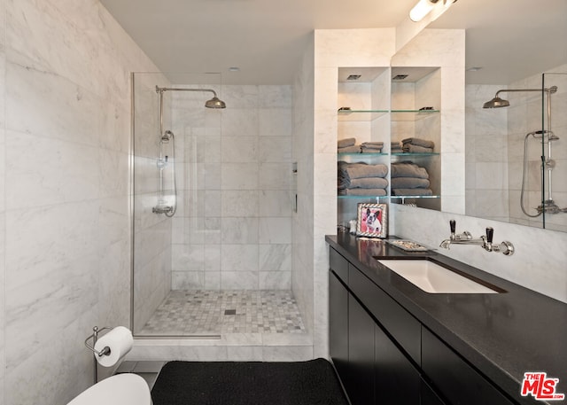 bathroom featuring a tile shower, vanity, and tile walls