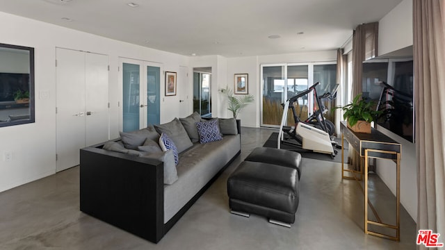 living room with french doors and concrete flooring