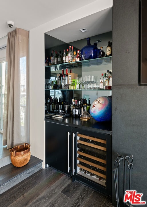 bar featuring dark wood-type flooring and beverage cooler