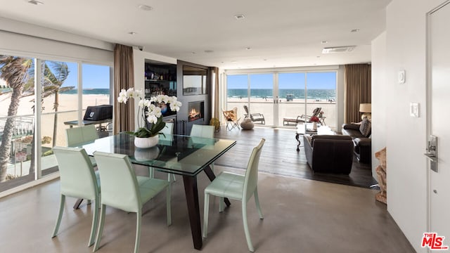 dining space with a wealth of natural light, a wall of windows, and a water view